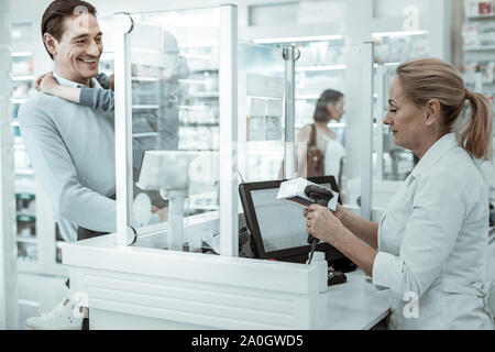 Une pharmacie travailleur féminin la numérisation du code barres de la medicine Banque D'Images