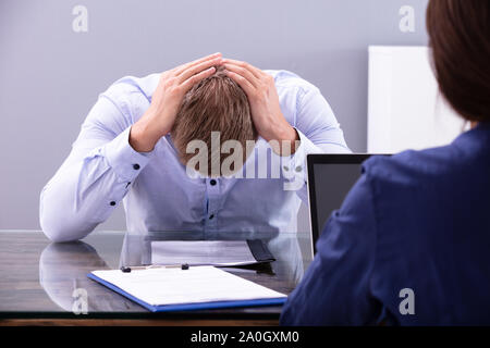 Les jeunes ont souligné Business Man Holding sa tête au moment de l'Interview in Office Banque D'Images