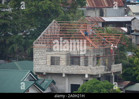 Un homme de fer de soudure des fermes de toit sur une maison privée à Cebu City, Philippines Banque D'Images