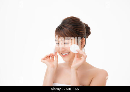 Femme Asiatique avec juste la peau éclat parfait mains tiennent un coton nettoyage ethnique face isolated on white Banque D'Images