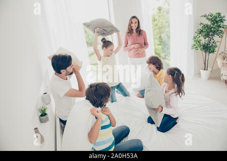 Grande belle belle belle famille adoptive gaies, six personnes, femmes enceintes maman, papa barbu et quatre enfants, frères et sœurs, jouant avec oreiller Banque D'Images