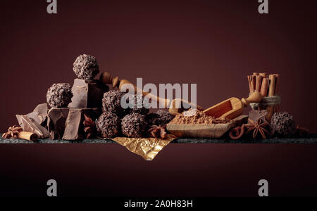 Truffes au chocolat avec des morceaux de chocolat et d'épices. Le chocolat, les bâtons de cannelle et anis sur fond sombre. Copier l'espace. Banque D'Images