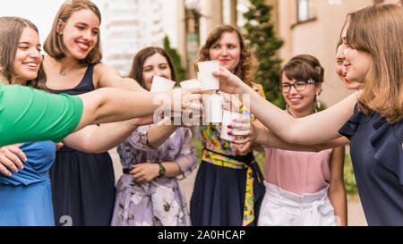 Groupe d'amies toasting with champagne dans le papier de verre. Les jeunes fête avec champagne à partie à l'extérieur. Concept de hen-partie ou corpor Banque D'Images