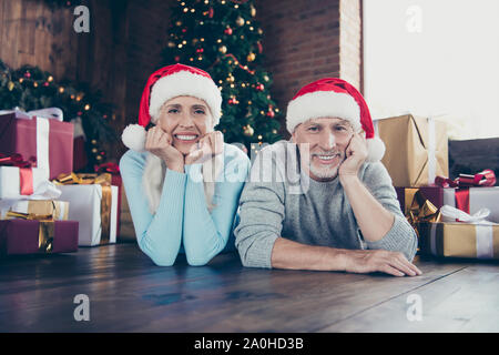 Portrait de deux heureux happy funny belle belle belle adorable époux grisonnant mari et femme couchée sur le plancher près de sapin parmi plusieurs lots o Banque D'Images