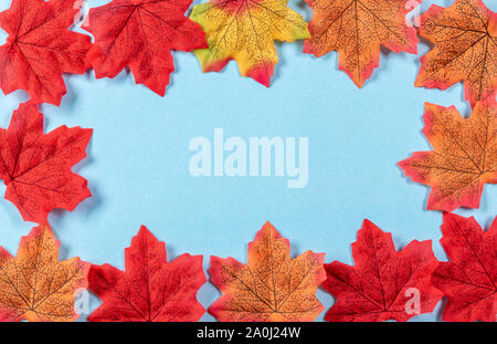 Concept d'automne. Cadre fabriqué à partir de feuilles d'érable sur fond bleu pastel. Banque D'Images