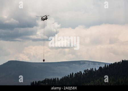 Un hélicoptère Chinook transporte l'eau de tomber sur un feu de forêt au Colorado Banque D'Images