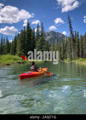 Teenage boy kayak sur les lacs Vermilion, dans le parc national Banff. Banque D'Images