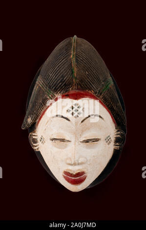 Le Punu masque féminin du Cameroun, Afrique, sculpté en bois isolé sur black Banque D'Images