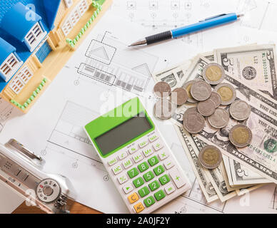 L'investissement pour la construction avec le budget, plan de construction, stylo, argent, maison modèle, l'appareil photo et la calculatrice sur table en bois Banque D'Images
