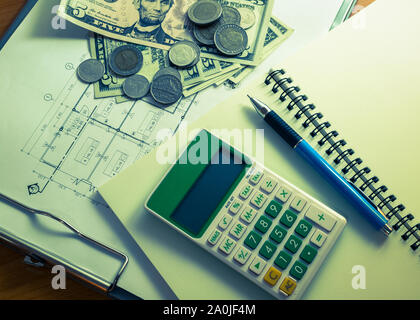 L'investissement pour la construction avec le budget, plan de construction, stylo, argent, ordinateur portable et calculatrice sur table en bois dans les couleurs traitées Banque D'Images