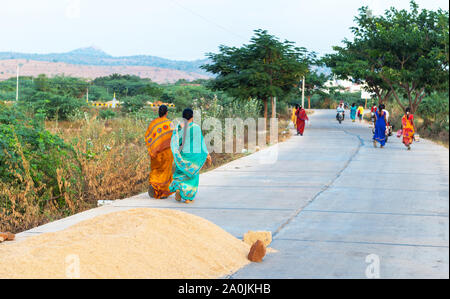 Les femmes indiennes en sari marche dans la rue, Puttaparthi, Inde. Vue arrière. Banque D'Images