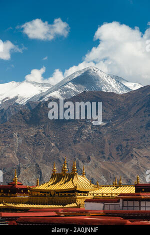 Les toits d'or du Temple de Jokhang position contre des montagnes enneigées à Lhassa, au Tibet. Le temple est le temple le plus saint dans tous les of Tibetan Budd Banque D'Images