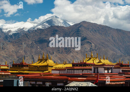 Les toits d'or du Temple de Jokhang position contre des montagnes enneigées à Lhassa, au Tibet. Le temple est le temple le plus saint dans tous les of Tibetan Budd Banque D'Images