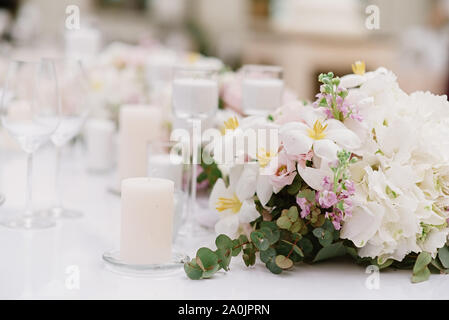 Décoration de luxe de la table de mariage blanc avec des bougies et des fleurs dans des tons clairs Banque D'Images