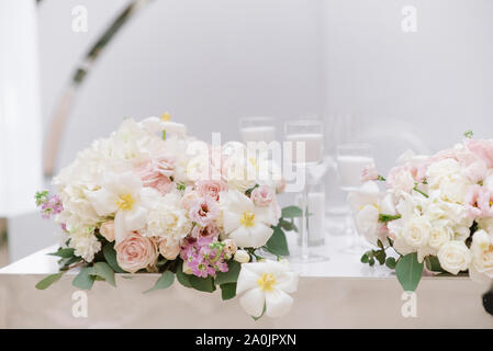 La décoration élégante du mariage moderne table avec bougies blanches et des fleurs dans des tons clairs. Banque D'Images