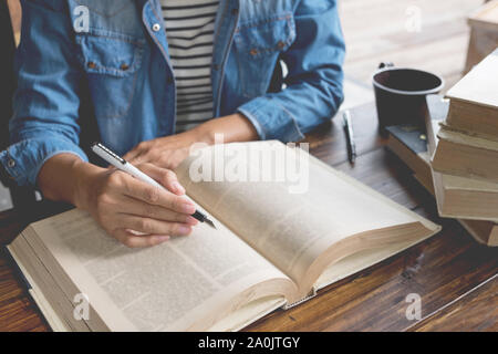 Femme assise dans un café, la lecture de livre. Banque D'Images