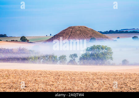 A la fin de l'été soleil levant sur Silbury Hill dans le Wiltshire. Banque D'Images