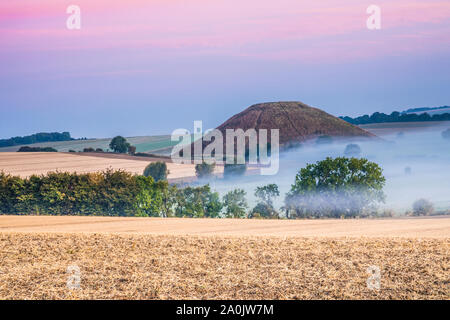 A la fin de l'été soleil levant sur Silbury Hill dans le Wiltshire. Banque D'Images