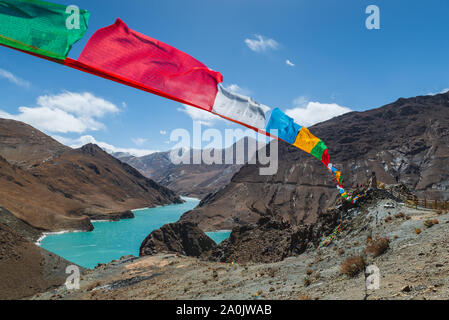 Les drapeaux de prières colorés voler haut sur le paysage tibétain. Banque D'Images