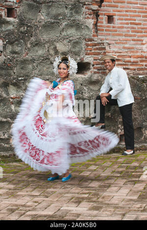 Femme portant un Panaméen pollera, Panama le costume national, des danses et un homme vêtu d'un mole traditionnel des montres à Panama la Vieja ruines, Panama Banque D'Images