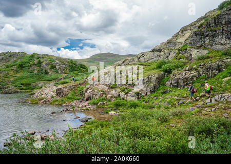 Quatre personnes randonnées autour du lac perdu au-dessus de la ligne des arbres dans les montagnes de San Juan, à l'aide de ses pôles de randonnée sur une journée d'été, Weminuche Wilderness, Rock Banque D'Images