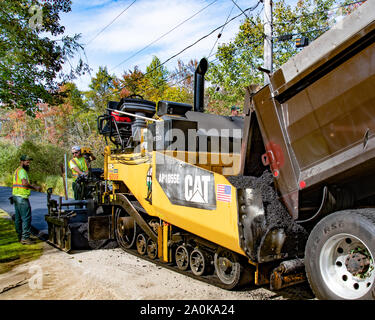 Un camion à benne et une machine de pavage asphalte neuf pose sur un village-rue de spéculateur, NY USA au début de l'automne Banque D'Images