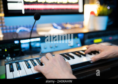 Mains de jeune musicien appuyer sur les touches du clavier du piano en studio d'enregistrement Banque D'Images