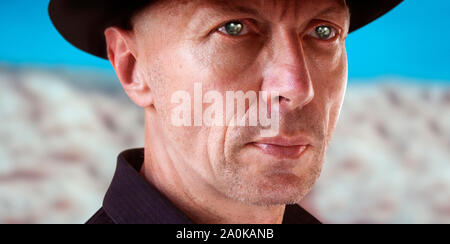 Close-up Portrait of Man in Cowboy Hat contre le fond du désert Banque D'Images