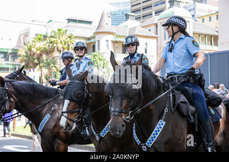 Les policiers de la Nouvelle-Galles du Sud à cheval contrôlent la foule lors du rassemblement de la grève du changement climatique de Sydney dans le centre-ville de Sydney, en Australie Banque D'Images