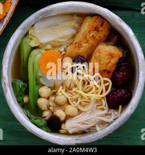 Soupe de nouilles végétaliennes vietnamiennes pour le petit déjeuner, plats végétariens faits maison du tofu, fruits jujujube, graines de lotus, bok choy, champignons, épices, plat sain Banque D'Images