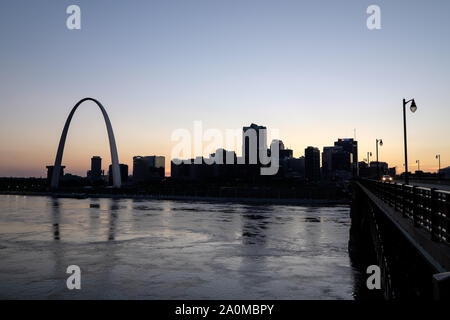 Avec le Gateway Arch se détachant sur un coucher de soleil colorés, les toits de Saint Louis est vu au cours de la rivière Mississippi Banque D'Images