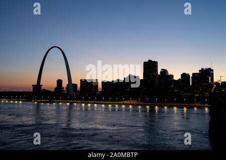 Avec le Gateway Arch se détachant sur un coucher de soleil colorés, les toits de Saint Louis est vu au cours de la rivière Mississippi Banque D'Images