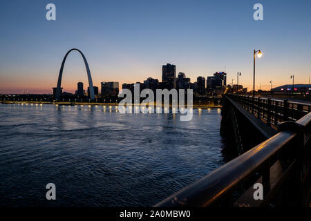 Avec le Gateway Arch se détachant sur un coucher de soleil colorés, les toits de Saint Louis est vu au cours de la rivière Mississippi Banque D'Images