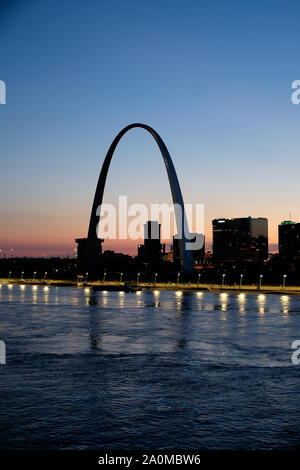 Avec le Gateway Arch se détachant sur un coucher de soleil colorés, les toits de Saint Louis est vu au cours de la rivière Mississippi Banque D'Images