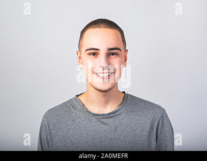 Happy casual young man smiling dentelée en vêtements décontractés sur fond bleu avec copie vide de l'espace. Closeup portrait Banque D'Images