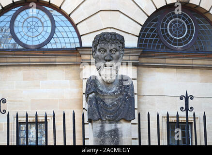 Une tête sculptée sur un pilier à l'extérieur du Sheldonian Theatre d'Oxford, a appelé les chefs de l'empereur mais probablement philosophes chefs chacun a un autre beard Banque D'Images