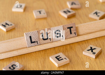 Lettres de scrabble en bois sur un rack l'orthographe du mot Luxure Banque D'Images