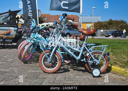 De Koog, Texel / Pays-Bas - Août 2019 : petit bleu des bicyclettes avec des roues d'entraînement pour les enfants à la station de location de vélo pour les touristes sur l'île Texel Banque D'Images