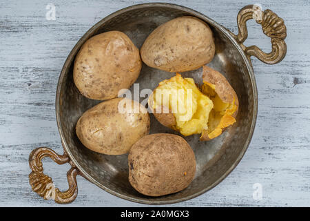 Pomme de terre au four dans un bol en métal sur une table en bois simple, la nourriture végétarienne. Pommes de terre, vue d'en haut, Banque D'Images