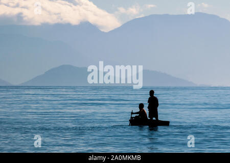 Ilha Grande, Brésil - 20 mars 2008 : deux hommes noirs brésiliens de l'aviron sur l'hâte au milieu de la mer, près de la côte de Abraao village. Banque D'Images