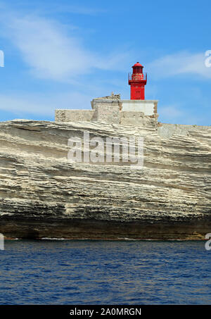 Phare rouge appelé MADONETTA sur les falaises blanches près de la ville de Bonifacio en Corse une île française de la Méditerranée en Europe Banque D'Images
