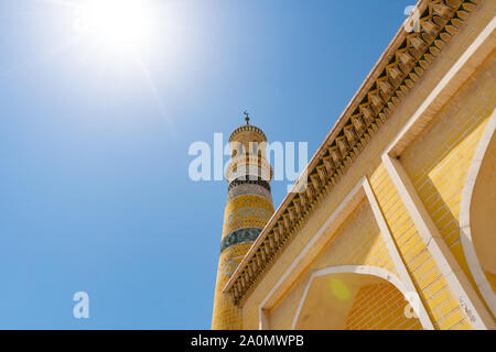 La mosquée Id Kah à Kashgar Low Angle View de carreaux de couleur jaune le Minaret sur un ciel bleu ensoleillé Jour Banque D'Images