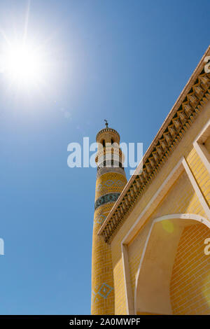 La mosquée Id Kah à Kashgar Low Angle View de carreaux de couleur jaune le Minaret sur un ciel bleu ensoleillé Jour Banque D'Images