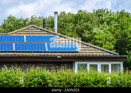 Une maison avec un panneaux panneaux solaires installés sur le toit de tuiles Banque D'Images