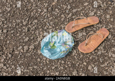 Hippy usés tongs & globe dégonflé sur surface des bardeaux. Métaphore 250-504, télévision earthers, théories du complot, preuve de la terre plate, la pseudoscience Banque D'Images