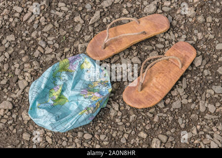 Hippy usés tongs & globe dégonflé sur surface des bardeaux. Métaphore 250-504, télévision earthers, théories du complot, preuve de la terre plate, la pseudoscience Banque D'Images