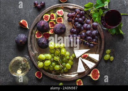 Dégustation de vins et fromages. Verre de vin blanc et rouge et de l'alimentation, fromages français, les figues et les raisins. Banque D'Images