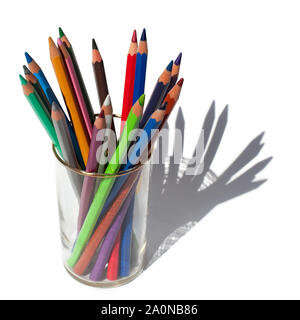 Crayons de couleurs différentes pour l'établissement dans un verre sur un fond blanc Banque D'Images