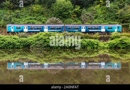 Cardiff, Wales, UK - 19 juillet 2019 : un 2-voiture Sprinter passenger train longe le bord de la rivière verte au Taff Radyr dans la banlieue de Cardiff. Banque D'Images