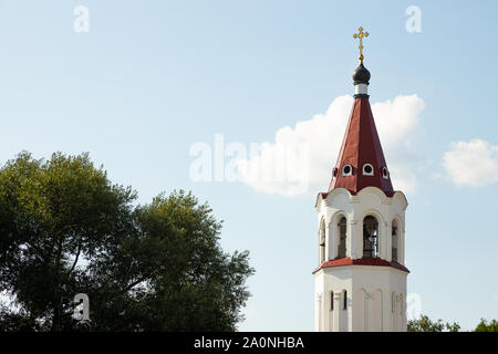 Close-up of red haut de l'église orthodoxe avec croix chambre bell contre ciel et les arbres Banque D'Images